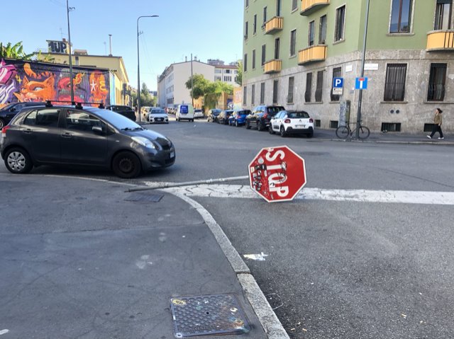 cartello stradale rotto disteso sulla carreggiata